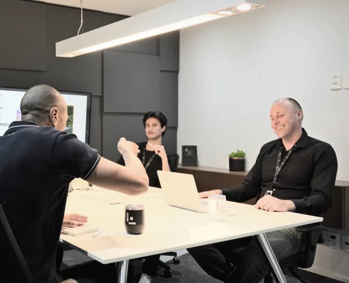 Reunião do time da Leven numa sala com mesa branca