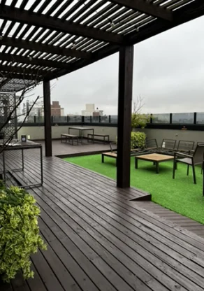 Terraço com pergolado, deque de madeira e grama