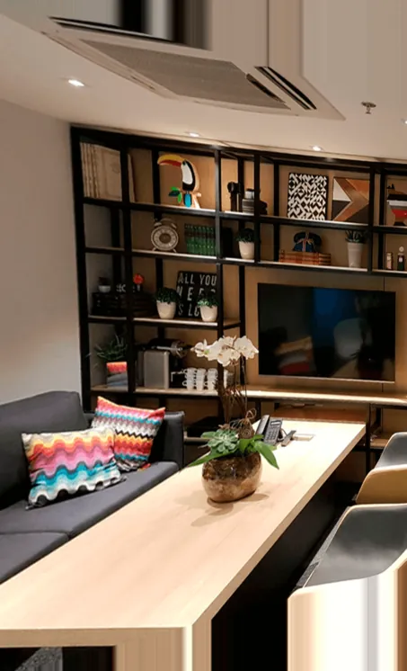 Estar do escritório, com estante, sofá e mesa de madeira