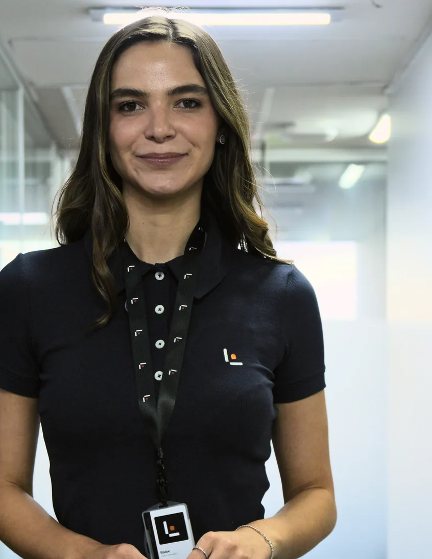 Integrante da Leven com o crachá da empresa, no corredor do escritório